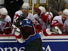 Colorado Avalanche Dan Hinote sends Red Wing captain Steve Yzerman flying into his own bench during the first period May 27, 2002 at Joe Louis Arena.