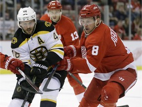 Red Wings forward Justin Abdelkader (8) battles for the puck with Boston Bruins centre David Krejci (46) during the first period of an NHL hockey game, Sunday, Feb. 14, 2016, in Detroit.
