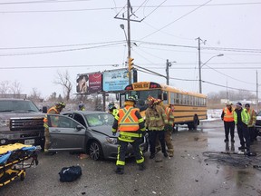 Firefighters work on an accident scene involving a car, a pick-up truck, and a school bus with children onboard at Provincial and Sixth Concession Road on Feb. 25, 2016.