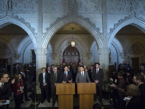 Surrounded by mayors and journalists, Prime Minister Justin Trudeau and Vancouver Mayor Gregor Robertson take part in a news conference in the Foyer of the House of Commons on Parliament Hill in Ottawa Friday, Feb. 5, 2016.