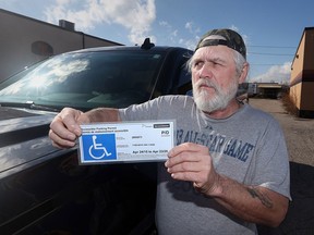 Doug Johnston displays his parking permit that he says was displayed when he received a ticket while at Windsor Regional Hospital's Ouellette Campus.