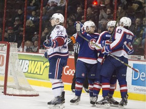 Windsor's Aaron Luchuk, centre-left, Cristiano DiGiacinto, and Gabriel Vilardi celebrate a first-period goal while Hamilton's Jack Hanley looks on in OHL action between the Windsor Spitfires and the Hamilton Bulldogs at the WFCU Centre, Sunday, Feb. 21, 2016.