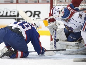 Windsor's Christian Fischer battles for the puck in front of Hamilton's Kaden Fulcher in OHL action between the Windsor Spitfires and the Hamilton Bulldogs at the WFCU Centre, Sunday, Feb. 21, 2016.