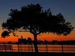 The setting sun is seen behind the Detroit skyline from Windsor at the end of an unseasonably warm Monday, Feb. 1, 2016.