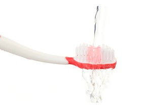 Water falling on a red toothbrush. Photo by fotolia.com