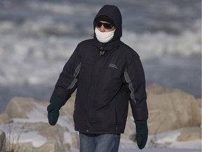 A man is dressed for the elements as he walks along the riverfront, Saturday, February 13, 2016.