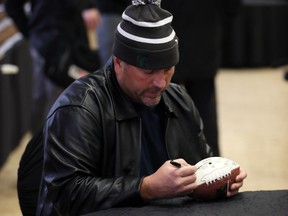 CFL coach Ed Philion autographs souvenirs last week before the Gridiron Gala at Giovanni Caboto Club of Windsor. NICK BRANCACCIO