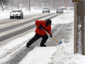 Windsor resident Peter Gerard puts a shovel to use on Riverside Drive East in this February 2013 file photo.