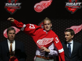 Anthony Mantha reacts puts on his jersey after being selected number twenty overall in the first round by the Detroit Red Wings during the 2013 NHL Draft at the Prudential Center on June 30, 2013 in Newark, New Jersey.