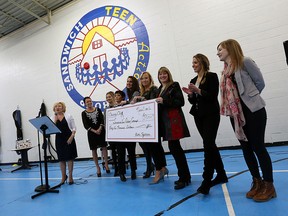 The Charity Chix present a cheque for $54,000 to the Sandwich Teen Action Group in Windsor on Wednesday, March 9, 2016. Part of the money will go towards a new gym floor. (TYLER BROWNBRIDGE/The Windsor Star)