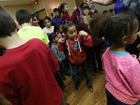 Recently arrived Syrian Nour Dabduk receives her backpack from the students of Talbot Trail Elementary school at the Days Inn Hotel in Windsor on Tuesday, March 29, 2016. Students at the school received a grant to purchase 65 backpacks. They then stuffed them with school and other supplies and were presented to children from Syria.