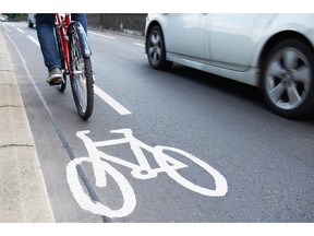 Bicyclist using cycle lane as traffic moves by. Photo by fotolia.com.