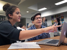 Students at F.J. Brennan High School participated in a volunteer blitz on Thursday, March 24, 2016, throughout the city and at the school. Jennifer Jaskiewicz, a grade 9 student helps Ken Jones, 78, learn some computer skills during an information session hosted for the event.