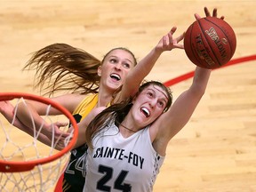 St. Clair Saints Rylee Welsh reaches over Dynamiques de Sainte-Foy's Isaeve Sirois during the  CCAA women's basketball championships held at St. Clair College in Windsor, Ont., on March 17, 2016.