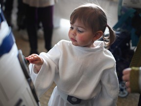 Danica Ward, 1, plays with the buttons on R2D2 while she attends the Christmas Comic Con 2 at the St. Clair Centre for the Arts, dressed as Princess Leia from Star Wars in this 2013 file photo.