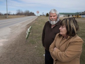 Dave Foulis, left, a close family friend, stands next to Carol-Ann Michaud, mother of Jean-Francois Michaud, 34, at the site of his death on the 200 block of Albuna Townline in Leamington, Ont., Sunday, March 20, 2016.