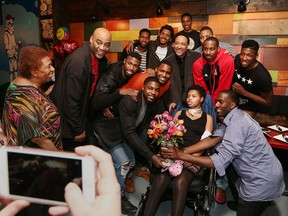 Darquetta Banks is surrounded by the Windsor Express basketball team at SnackBar-B-Q restaurant in Windsor, Ont. on March 16, 2016.