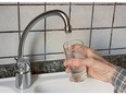 Filling glass of water from the kitchen tap, drinking water supply. Photo by fotolia.com