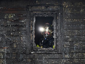 A Windsor firefighter is shown at the scene of a fire on Wednesday, March 23, 2016, in the 1100 block of Hickory Road in Windsor, Ont. The fire broke out shortly after 2:00 p.m. and caused extensive damage to two homes.