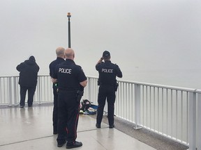 Windsor police officers investigate a floating ATV in the Detroit river on Monday, March 14, 2016. A coast guard boat eventually picked up the small vehicle.