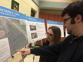 Chris and Evelyn Diakantoniou examine a report from Stantec Consulting outlining solutions for flooding in LaSalle's Heritage Estates and Oliver Farms on March 30, 2016.