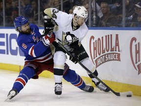 New York Rangers' Kevin Klein, left, is knocked down while trying to get the puck from Pittsburgh Penguins' Tom Kuhnhackl during the first period of the NHL hockey game on March 27, 2016, in New York.