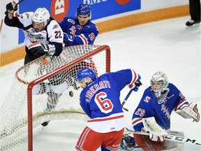 Kitchener Rangers defender Doug Blaisdell checks Windsor Spitfires forward Brendan Lemieux into the net as defender Miles Liberati and goalie Luke Oplika keep their eyes on the puck in their quarter final playoff game at the Aud.