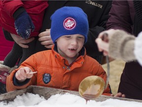 Carson Young, 6, gets ready to wind some taffy in snow during the John R. Park Homestead's Maple Syrup Festival, Sunday, March 6, 2016.