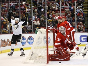 Pittsburgh Penguins' Nick Bonino, left, celebrates his third period goal against Detroit Red Wings' Jimmy Howard (35) Saturday, March 26, 2016, in Detroit.