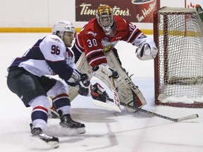 Owen Sound goalie Daniel Deconing stick checks the puck away from a charging Brendan Lemieux of the Spitfires during Ontario Hockey League action on March 12, 2016 in Owen Sound.