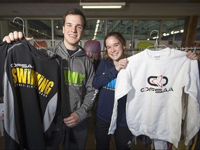 E.J. Lajeunesse students, Holly Lucier, 15, and Austin Comtois, 17, left, sell OFSAA gear at the Windsor International Aquatic and Training Centre, Monday, March 7, 2016.