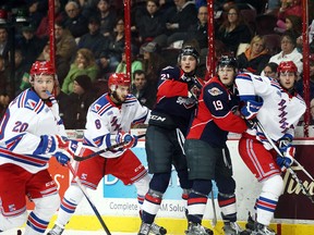 The Windsor Spitfires and Kitchener Rangers get jammed up on the boards during the Ontario Hockey League game at the WFCU Centre on March 17, 2016.