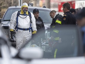 A Windsor police officer dressed in a hazmat suit prepares to investigate a suspicious package at a residential high-rise at 1333 Ouellette Ave., Tuesday, March 8, 2016.