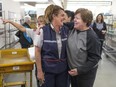 Postal employees, Sherri Mailloux, left, and Heather Sharpe enjoy a laugh while reminiscing during a gathering of former and current employees at the Canada Post office in the Paul Martin Building March 11,  2016.