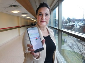 Gina Bulcke, director of organizational effectiveness at the Windsor Regional Hospital Ouellette campus, displays an app that helps track empty rooms and better manage patients on March 14, 2016.