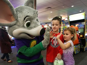 Jack and Eva James from Belle River get a high five from Chuck E. Cheese while they take part in the Chuck E. Cheese fundraiser for the SickKids Foundation in Toronto.