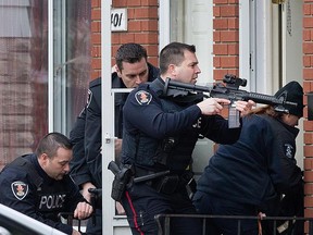 Windsor police officers prepare to enter a residence at 399 Bridge Ave. after a robbery suspect refused to come out.