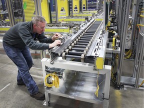 Graig Sutton, a robotics programmer at Valiant Machine and Tool in Windsor, Ont., works on a roller conveyor unit on March 14, 2016. The company recently won a supplier of the year award from General Motors.