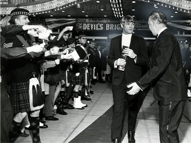 Autograph hunters wave their paper bait at actor Jeremy Slate as he leaves the Vanity Theatre on May 14, 1968.