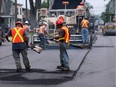 Paving specialist Eugenio Ferlaino, centre right, works with a paving crew from Mill-Am Contractors on Pillette Avenue south of Tecumseh Road East in this file photo.