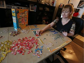 Jodie Desbiens puts together a jigsaw puzzle at her home in downtown Windsor on March 10, 2016. She's hoping to break the Guinness World Record for largest jigsaw puzzle collection.