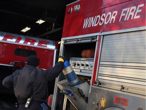 A Windsor firefighter, right, removes air supply tanks from the Emergency Supply Unit (ESU) vehicle at Fire Station 2 December 10, 2013.