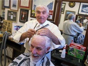 In this 2010 file photo, Barber Sal Lopez cuts the hair of long-time customer Spike Bell at the Wyandotte Street west barber shop.  Lopez died at  the age of 85.