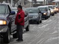 Windsor, Ontario. February 24, 2016 --  Brian Lamore speaks with motorists while they were double parked on St. James Street waiting for their children at St. James Catholic Elementary School. Parents and grandparents of children who attend the west side school are concerned over expensive parking tickets issued to vehicles which "double park" for about 20 minutes Wednesday February 24, 2016. (NICK BRANCACCIO/Windsor Star)