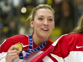 In this April 14, 2012, file photo, Canada's Meghan Agosta shows off her gold medal after Canada defeated the United States at the World Women's Ice Hockey Championships in Burlington, Vt. Agosta has seen some things as a new constable in the Vancouver Police Department. She returns to the Canadian women's hockey team a changed woman. THE CANADIAN PRESS/Paul Chiasson