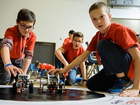 Jordan Bernard, left, and Michael Ricci, middle, and Max Holmgren, right, test out some last minute modifications to their robot in the gymnasium at Ecole Secondaire Michel-Gratton in Windsor, Ont on Tuesday, April 5, 2016. Students are all supplied with the same control module supplied by LEGO Inc. and are then allowed to find or create their own parts using methods like 3D printing.