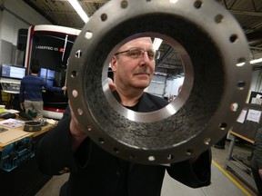 Marv Fiebig, president of PTooling displays a product manufactured with a new additive manufacturing machine.  It is the first of its kind in North America.