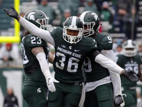 Michigan State's Arjen Colquhoun (36), Chris Frey (23) and Montae Nicholson celebrate a play during the fourth quarter of an NCAA college football game against Purdue, Saturday, Oct. 3, 2015, in East Lansing, Mich. Michigan State won 24-21.