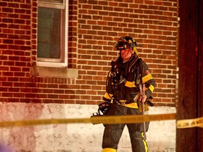 A firefighter works at the scene of a house fire at 1392 Bruce Ave. on the night of March 31, 2016.