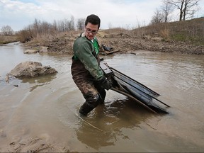 The Caesars Windsor Code Green team of employees and the Essex Region Conservation Authority were busy cleaning up a portion of the Little River watershed near the Twin Oaks industrial complex on Wednesday, April 13, 2016. Gary Filiatrault pulls a bed out of the Little River.